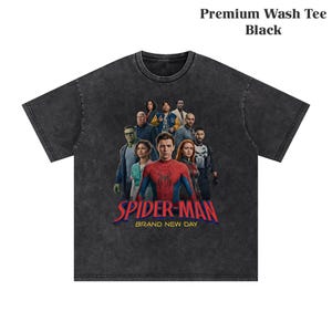 Op de afbeelding: Zwart premium wash t-shirt met een afbeelding van Spider-Man en andere personages. De tekst "SPIDER-MAN BRAND NEW DAY" is in rood en blauw. Het t-shirt is gemaakt van een zacht, comfortabel materiaal.