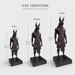 May include: Three black geometric Anubis statues in small, medium, and large sizes. The small statue is 9 1/2 inches tall, the medium is 11 1/8 inches tall, and the large is 13 inches tall. Text reads SIZE VARIATIONS, SMALL, MEDIUM, LARGE.