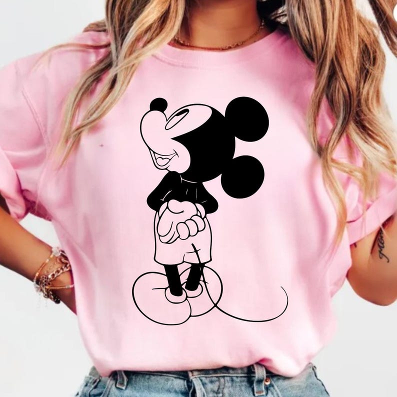 May include: A white ceramic mug with a black handle and the text "But First, Coffee" in a bold, black font. The mug is set against a blurred background, suggesting a cozy setting.
