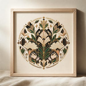 K&ouml;nnte beinhalten: Eine quadratisch gerahmte Kreuzstichstickerei mit einem kreisf&ouml;rmigen botanischen Muster. Das Design zeigt symmetrische Blumen- und Blattmotive in den Farben Dunkelgr&uuml;n, Creme, Schwarz und zartem Rosa auf einem hellbeigen Stoffhintergrund.