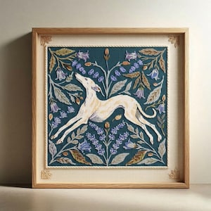Op de afbeelding: Een ingelijst kruissteekkunstwerk met een crème-kleurige windhond die springt te midden van blauwe en paarse bloemmotieven op een teal-kleurige achtergrond. Het kunstwerk is ingelijst in een licht houten frame met decoratieve hoekaccenten.
