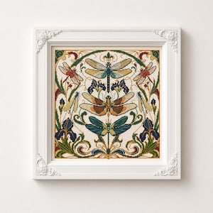 May include: A framed cross-stitch embroidery featuring three large dragonflies in shades of gold, brown, and teal, surrounded by dark blue iris flowers and green foliage. The design is symmetrical with intricate scrollwork in a white ornate frame.
