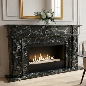 Puede incluir: Una chimenea de mármol negro con vetas blancas, con un diseño moderno. La chimenea tiene un interior negro con fuego de gas y está flanqueada por una mesa de comedor y sillas de mármol a juego. Un espejo con marco dorado cuelga encima.