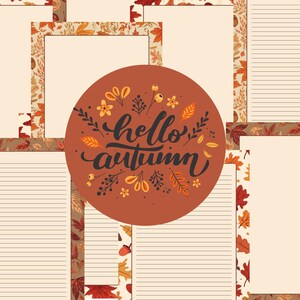 May include: A stationery set with lined and blank paper, decorated with autumn leaf borders. A central circular design displays the words "hello autumn" in script, encircled by leaves and floral motifs. The colour scheme features warm browns, oranges, and cream.