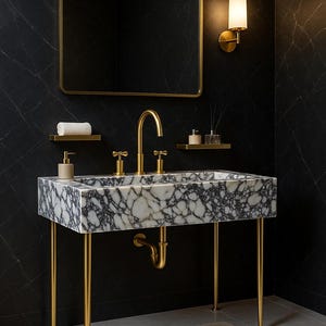 Op de afbeelding: Een moderne badkamerwastafel met een marmeren aanrechtblad en gouden armaturen. De wastafel wordt ondersteund door gouden poten en heeft een bijpassende gouden kraan en spiegel. Er ligt een klein tapijt op de vloer.