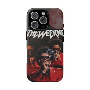 May include: Black phone case featuring a collage of images of The Weeknd in a red suit and sunglasses. The text "THE WEEKND" is in white, stylized font. A red moon is in the background.