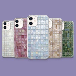 Op de afbeelding: Vijf telefoonhoesjes met een mozaïektegelontwerp in verschillende kleuren: wit, paars, lichtblauw, beige en groen. Elke hoes heeft een transparante rand en een camera-uitsparing. De hoesjes zijn in een rij gerangschikt tegen een paarse achtergrond.