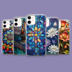 Op de afbeelding: Een verzameling van vijf telefoonhoesjes met kleurrijke glas-in-lood ontwerpen. De hoesjes tonen verschillende afbeeldingen, waaronder een zeilboot, een bloem en bloemmotieven in blauwe, oranje en paarse tinten. De hoesjes worden gepresenteerd tegen een paarse achtergrond.