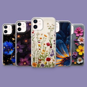 Puede incluir: Una colección de cinco fundas para teléfonos con diseños florales. Las fundas presentan varios patrones de flores, incluyendo acianos azules, explosiones de estrellas moradas y doradas, y flores silvestres coloridas. Las fundas se muestran sobre un fondo púrpura.