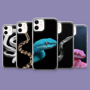 Op de afbeelding: Een verzameling telefoonhoesjes met close-up afbeeldingen van verschillende slangen. De hoesjes tonen een reeks slangensoorten, waaronder een witte slang, een bruine en bruine slang, een blauwe slang, een grijze slang en een roze slang, allemaal tegen een zwarte achtergrond.
