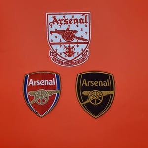 May include: A white ceramic mug with a black handle and the text "But First, Coffee" in a bold, black font. The mug is set against a neutral background, highlighting its simple design.