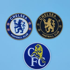 May include: Three circular patches featuring the Chelsea Football Club logo. The patches are blue, white, and black, with the club's name and "Football Club" text. The logos include a lion holding a staff.
