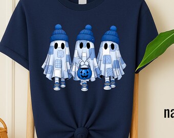 May include: Navy blue t-shirt featuring a graphic of three cartoon ghosts wearing blue hats and patchwork outfits, holding a blue pumpkin bucket. The word "navy" is printed on the bottom right.