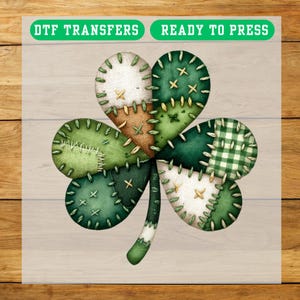 May include: A DTF transfer featuring a patchwork shamrock design. The shamrock is composed of various shades of green fabric, including a gingham pattern, with stitched details and a white stem. The text "DTF TRANSFERS READY TO PRESS" is at the top.