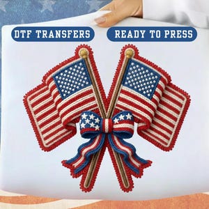 May include: A patriotic design featuring two American flags with red and white stripes and blue star fields. A bow with red, white, and blue accents is between the flags. The text "DTF TRANSFERS" and "READY TO PRESS" are at the top.