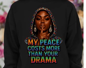 May include: Black sweatshirt featuring a portrait of a woman with a finger over her lips, wearing a jeweled hood. The text "MY PEACE COSTS MORE THAN YOUR DRAMA" is displayed in colorful letters.