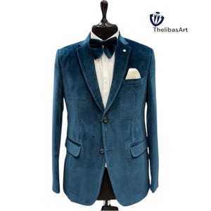 May include: A teal velvet blazer with a matching bow tie and pocket square. The jacket has a two-button closure and a white dress shirt underneath. ThelibasArt logo is in the upper right corner.