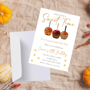 May include: A white invitation card with gold text and illustrations. The card reads "join us for a Sweet Time" and "It's a Caramel Apple Bar Party." The invitation is for Emma's 10th birthday, with the date, time, and location.