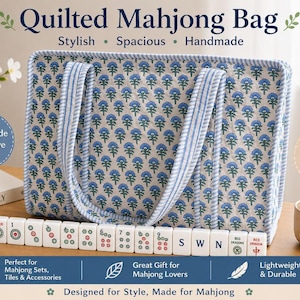 Blue floral quilted mahjong tote bag with striped handles and spacious padded design, displayed with American mahjong tiles and cozy tabletop decor, featuring a stylish handmade large-capacity organizer for mahjong sets and accessories.