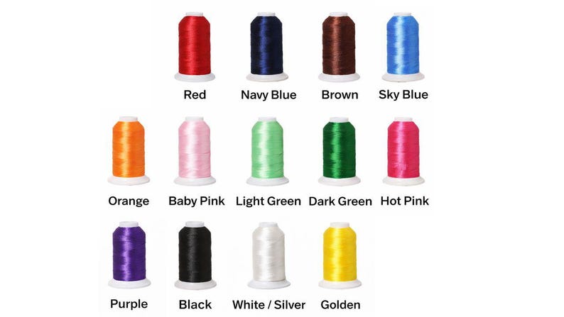 K&ouml;nnte beinhalten: Eine Sammlung von vierzehn Stickgarnspulen, die in drei Reihen angeordnet sind. Die Farben umfassen Rot, Marineblau, Braun, Himmelblau, Orange, Babyrosa, Hellgr&uuml;n, Dunkelgr&uuml;n, Pink, Lila, Schwarz, Wei&szlig;/Silber und Gold.