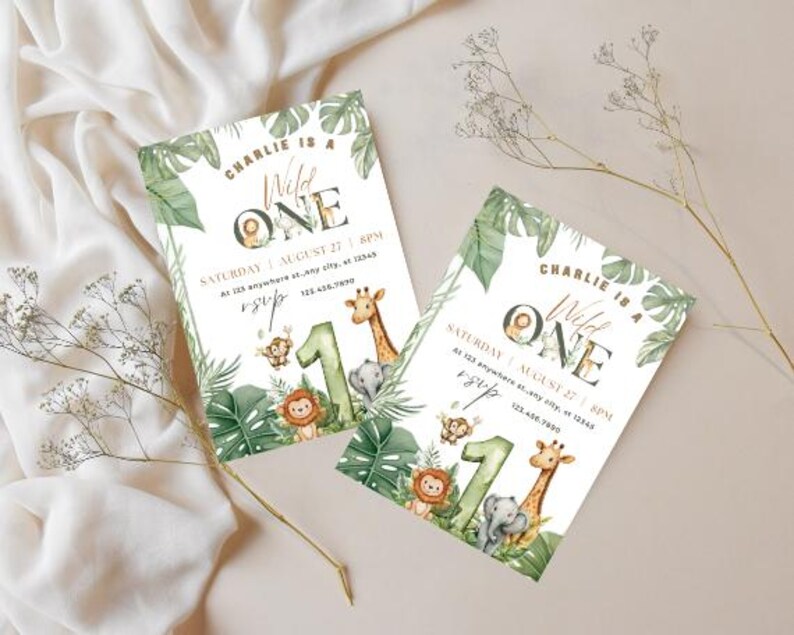 May include: Two invitations with a jungle theme. The invitations read "Charlie is a Wild One" with illustrations of a lion, giraffe, elephant, and monkey. The invitations are decorated with green leaves and the number "1".