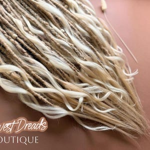 a close-up view of a collection of blonde dreads, with the text "Harvest Dreads Boutique" written in the background.