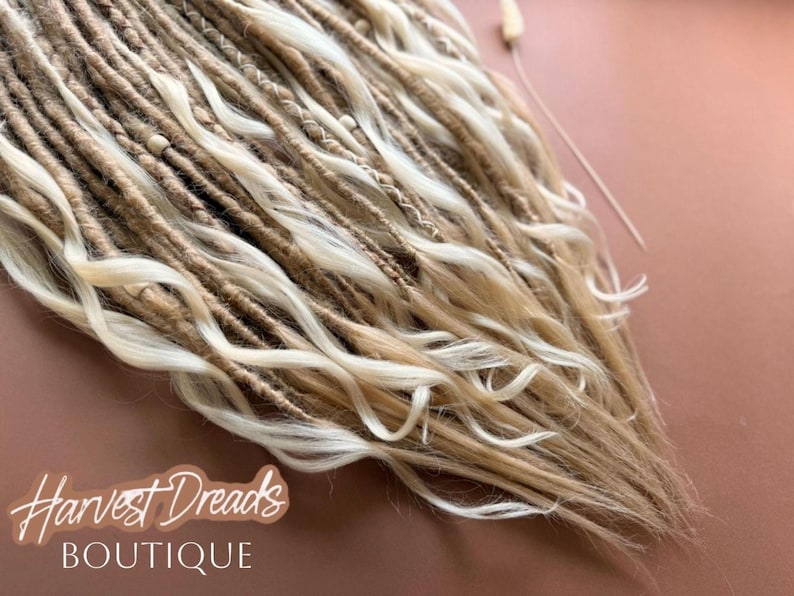 a close-up view of a collection of blonde dreads, with the text "Harvest Dreads Boutique" written in the background.