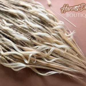 a close-up view of a collection of blonde braided hair strands, with the text "Harvest Dreads Boutique" written in the background.