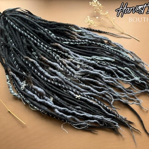 May include: A collection of black and grey dreadlocks with diverse textures and designs. Some dreads are solid black, others have grey and white highlights. The text "Harvest Dreads Boutique" is visible in the upper right corner.