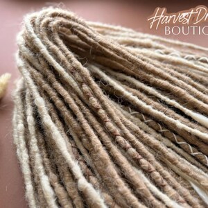 A close-up view of a bundle of brown and beige braided hair, with the text "Harvest Dreads Boutique" written in cursive above it.