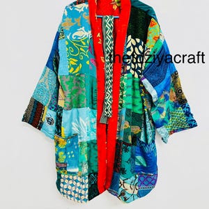 Könnte beinhalten: Patchwork-Kimono-Jacke in Blau-, Grün- und Gelbtönen mit rotem Innenfutter und Besatz. Die Jacke weist eine Vielzahl von Stoffmustern und -strukturen auf, und der Text "theziyacraft" ist auf der Vorderseite sichtbar.