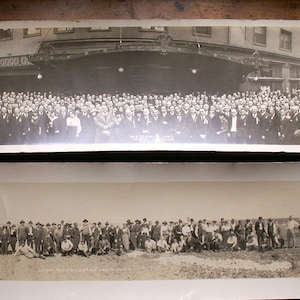 May include: Two vintage black and white photographs. The top photo shows a large group of people in front of a building. The bottom photo shows a group of people in a field. Both photos are framed.