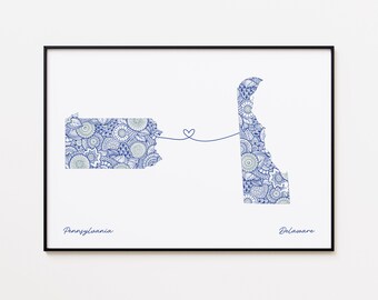 Könnte beinhalten: Gerahmter Druck mit den Umrissen von Pennsylvania und Delaware, verbunden durch ein Herz. Die Bundesstaaten sind mit einem blau-weißen Blumenmuster gefüllt. Die Wörter "Pennsylvania" und "Delaware" sind unten geschrieben.