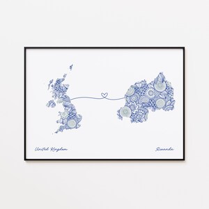 May include: Framed art print featuring detailed blue and white patterned maps of the United Kingdom and Rwanda, connected by a heart-shaped line. The words "United Kingdom" and "Rwanda" are written below the maps.