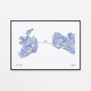 May include: A framed print featuring detailed blue and white patterned maps of Ireland and Libya, connected by a heart-shaped line. The word "Ireland" is written below the Irish map, and "Libya" is written below the Libyan map.