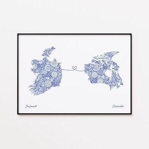 Puede incluir: Un póster enmarcado con mapas detallados en azul de Irlanda y Canadá, conectados por una línea en forma de corazón. Los nombres "Irlanda" y "Canadá" están escritos debajo de los mapas.