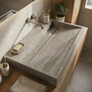 May include: A contemporary bathroom sink crafted from grey marble, featuring an integrated drain. The rectangular sink is set on a wooden cabinet. A stainless steel tap is mounted on the wall above. A bar of soap rests in a soap dish.