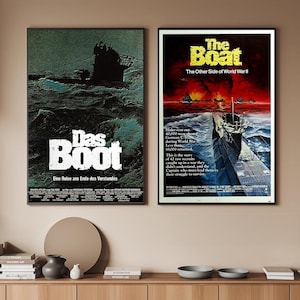 May include: Two framed film posters. The left poster is for "Das Boot" featuring a submarine at sea. The right poster is for "The Boat" with a submarine and text about World War II.