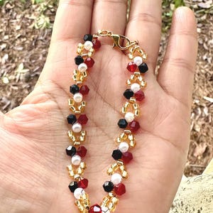 Beaded bicone bracelet. synthetic red garnet and black onyx.