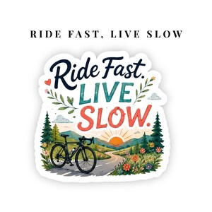 May include: A die-cut sticker featuring the text "Ride Fast, LIVE SLOW" in dark blue, teal, and red lettering. The design includes a black road bike on a winding path, a sunrise over distant mountains, pine trees, and colorful wildflowers.