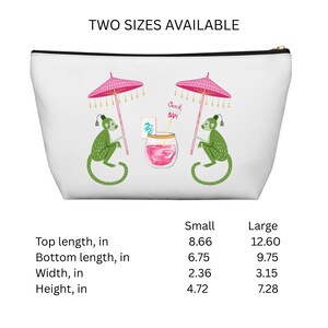May include: White cosmetic bag with a black zipper, featuring a whimsical design of two green monkeys holding pink umbrellas. A cocktail with the text "Crack BAM" is in the center. The bag is available in two sizes, with a top length of 8.66 inches and 12.60 inches.
