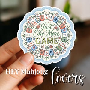 May include: A round sticker with a light blue scalloped edge featuring a floral design and various Mahjong tiles. The text "Just One More GAME" is in the center. The sticker also includes the text "HEY Mahjong lovers".