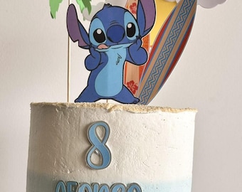 Pode incluir: Bolo de dois andares com cobertura degradê azul e branco, decorado com um personagem de desenho animado Stitch, uma prancha de surf, um sol, uma palmeira e o número 8. O nome "Afonso" está escrito no bolo.