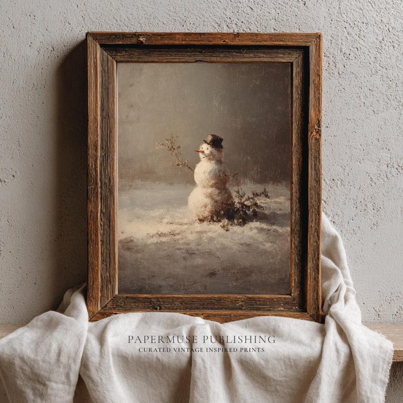 May include: A framed vintage print depicts a snowman in a snowy landscape. The snowman wears a small hat and has twig arms. The artwork is in a rustic wooden frame, with the text "PAPERMUSE PUBLISHING" and "CURATED VINTAGE INSPIRED PRINTS" at the bottom.