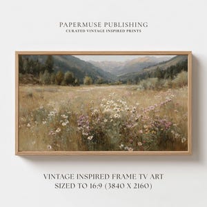 Peut inclure: Une impression encadrée d'un paysage avec un champ de fleurs sauvages blanches et violettes, avec une chaîne de montagnes en arrière-plan. L'impression est dans un cadre en bois et comprend le texte "PAPERMUSE PUBLISHING" et "VINTAGE INSPIRED FRAME TV ART".