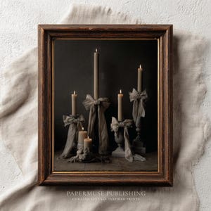 May include: A framed print showing lit candles of varying heights, decorated with draped fabric bows. The candles are in shades of beige and grey, set against a dark background. The frame is a dark brown with a gold trim. The text "PAPERMUSE PUBLISHING" is at the bottom.