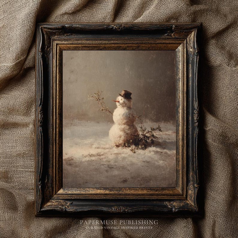 May include: A framed vintage print of a snowman in a snowy landscape. The snowman wears a small hat and has a carrot nose. The frame is dark with ornate detailing. The print is from PaperMuse Publishing.