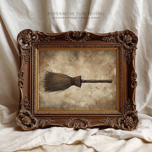 May include: A framed print featuring a detailed illustration of a broom. The artwork is set against a sepia-toned background and is enclosed within an ornate, dark brown wooden frame. The text "PAPERMUSE PUBLISHING CURATED VINTAGE INSPIRED PRINTS" is at the top.