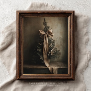 May include: A framed print depicting a miniature Christmas tree decorated with a large ribbon. The artwork has a muted colour palette and the text "PAPERMUSE PUBLISHING" and "CURATED VINTAGE INSPIRED PRINTS" is visible at the bottom.
