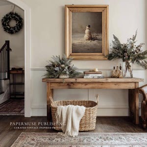 May include: A rustic wooden console table with a framed vintage snowman print, floral arrangements, and a woven basket with a cream-colored throw. A wreath hangs on the wall. The image is from Papermuse Publishing.